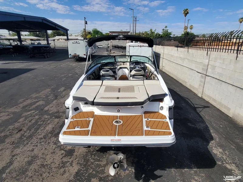 Slide: The Image of 2023 Monterey 238SS boat with spacious deck and seating, parked outdoors. - 7