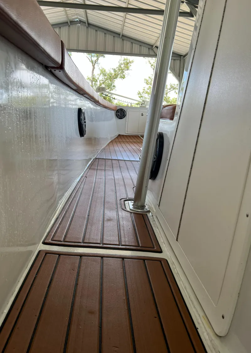 Slide: The Image of Alt text: 1986 Custom 38 Coyote boat interior with wooden deck and white walls. - 11