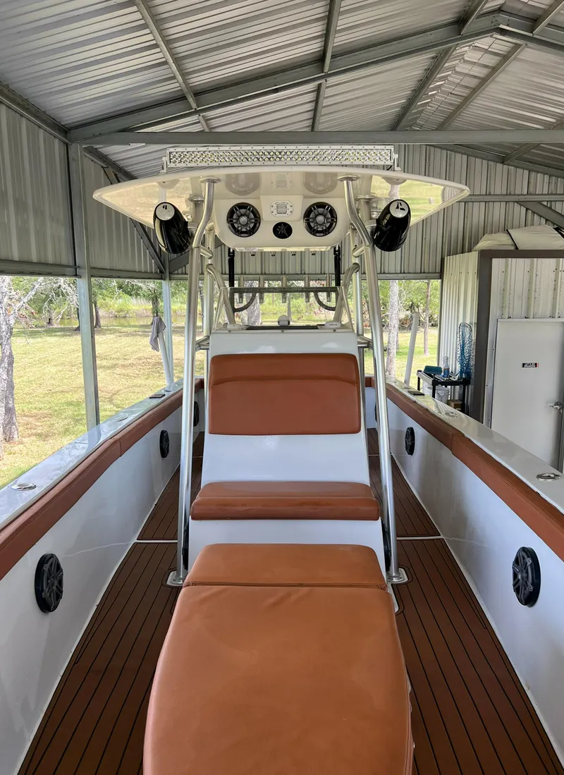 Slide: The Image of 1986 Custom 38 Coyote boat with brown seating and white interior under a metal shelter. - 12