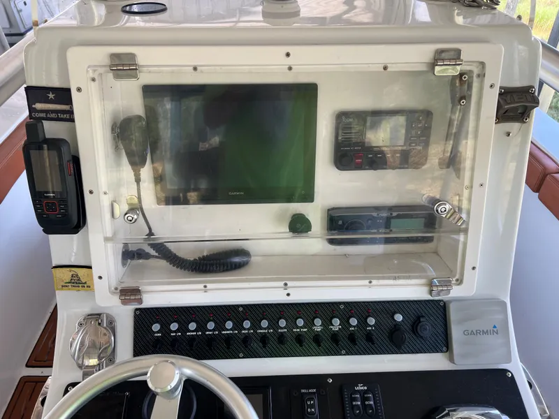 Slide: The Image of 1986 Custom 38 Coyote boat dashboard with Garmin navigation system and control panel. - 14