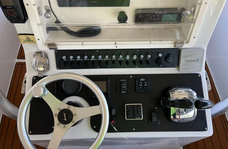 Slide: The Image of Control panel of a 1986 Custom 38 Coyote boat with steering wheel and navigation equipment. - 15