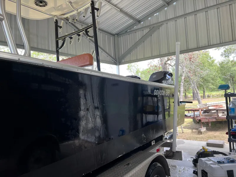 Slide: The Image of 1986 Custom 38 Coyote boat in a metal shed, side view. - 3