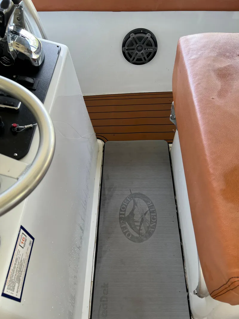 Slide: The Image of Interior of a 1986 Custom 38 Coyote boat with brown seating and steering wheel. - 4