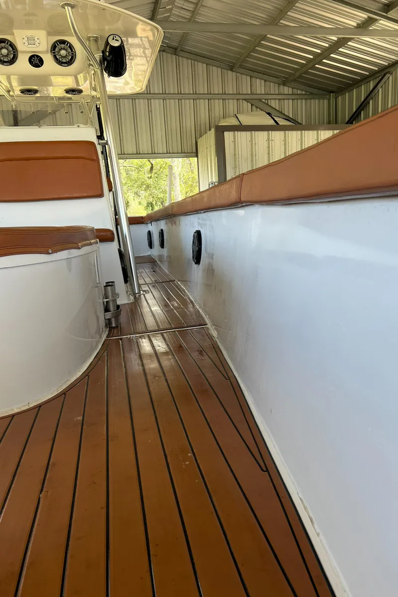 Slide: The Image of 1986 Custom 38 Coyote boat with wooden deck and white hull in a covered dock. - 7