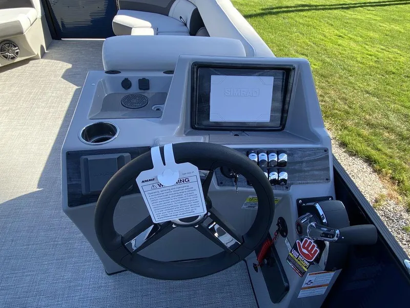 Slide: The Image of 2023 Harris Cruiser 230 CWDH boat helm with steering wheel and control panel. - 10