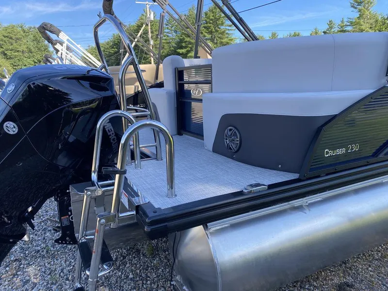 Slide: The Image of 2023 Harris Cruiser 230 CWDH pontoon boat with outboard motor and rear seating. - 2