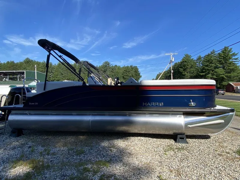 Slide: The Image of 2023 Harris Cruiser 230 CWDH pontoon boat on gravel lot under clear blue sky. - 4