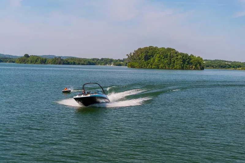 Slide: The Image of 2023 Yamaha Boats AR195 speeding on a lake with an island in the background. - 10