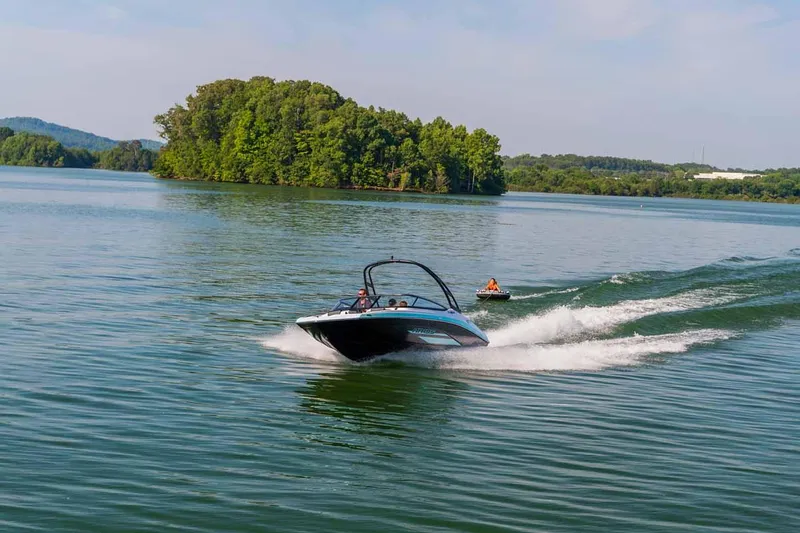 Slide: The Image of 2023 Yamaha Boats AR195 speeding on a lake with lush green island. - 14