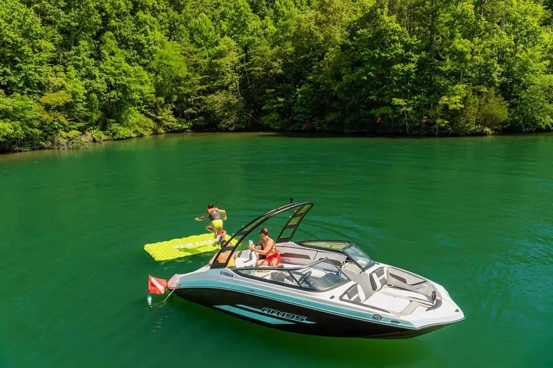 Slide: The Image of 2023 Yamaha Boats AR195 on a serene lake with lush green surroundings. - 15