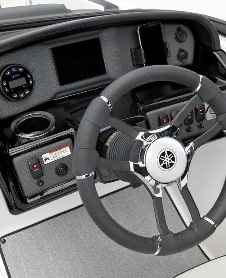 Slide: The Image of 2023 Yamaha Boats AR195 steering wheel and dashboard controls. - 2