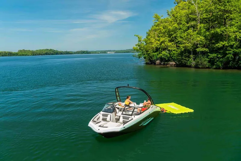 Slide: The Image of 2023 Yamaha Boats AR195 on a serene lake with lush green surroundings. - 9