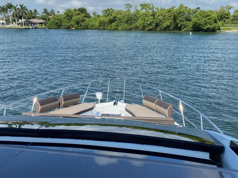Slide: The Image of Galeon 470 Skydeck 2022 yacht cruising on a serene lake with lush greenery. - 4