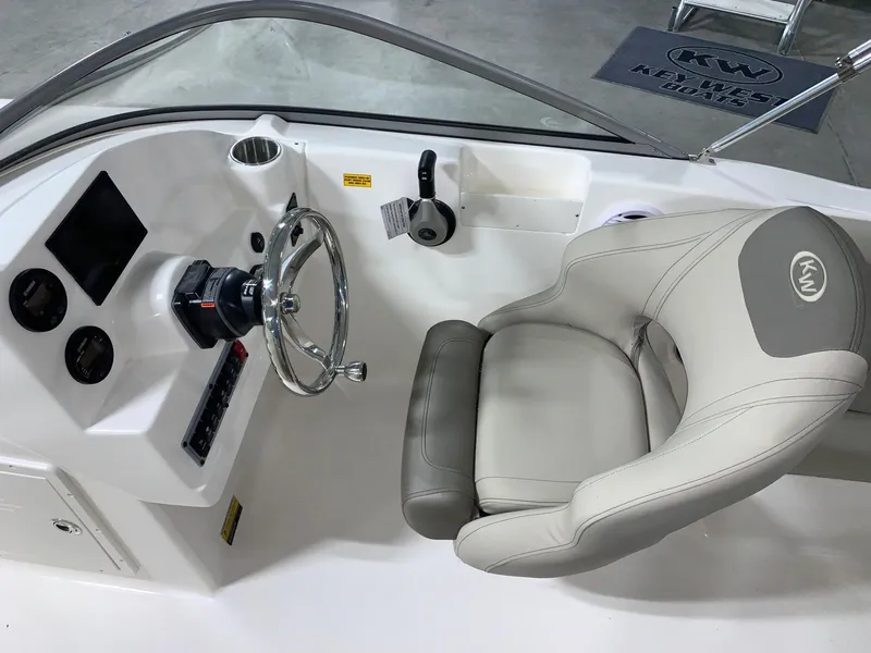 Slide: The Image of 2024 Key West 203 DFS boat cockpit with steering wheel and captain's chair. - 10
