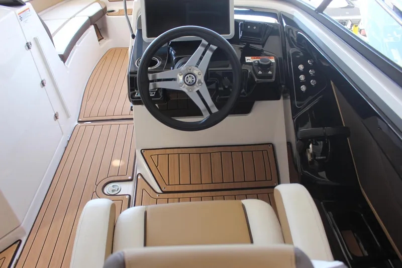 Slide: The Image of 2023 Yamaha Boats 252SE cockpit with modern steering wheel and teak flooring. - 6