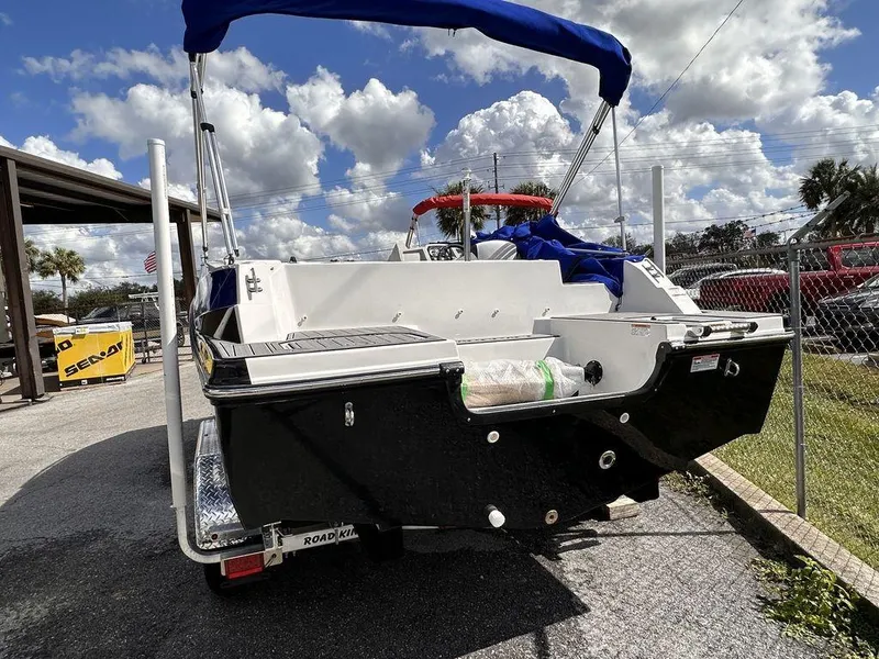 Slide: The Image of 2023 Starcraft SVX 191 boat with blue canopy, parked on a trailer. - 7