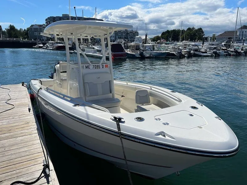 Slide: The Image of 2020 Mako 236 CC boat docked in marina under clear sky. - 2