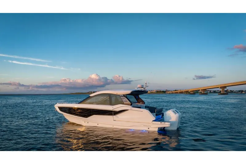 Slide: The Image of 2023 Galeon 375 GTO luxury yacht on serene waters at sunset. - 4