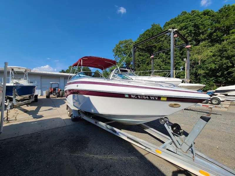 The Image of 2003 Crownline 230BR boat on a trailer in a marina. - 0