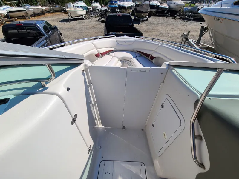 Slide: The Image of 2003 Crownline 230BR boat interior with white seating and storage compartments. - 14