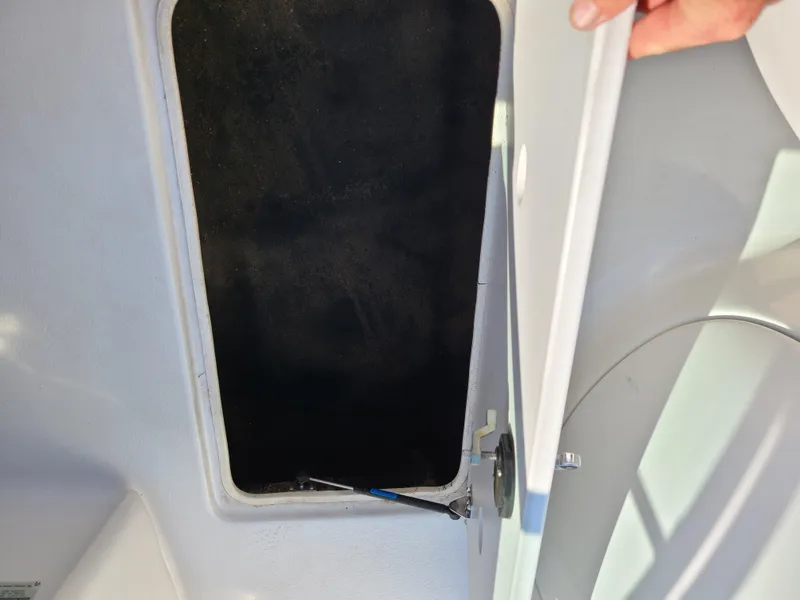 Slide: The Image of Open storage compartment on a 2003 Crownline 230BR boat. - 24