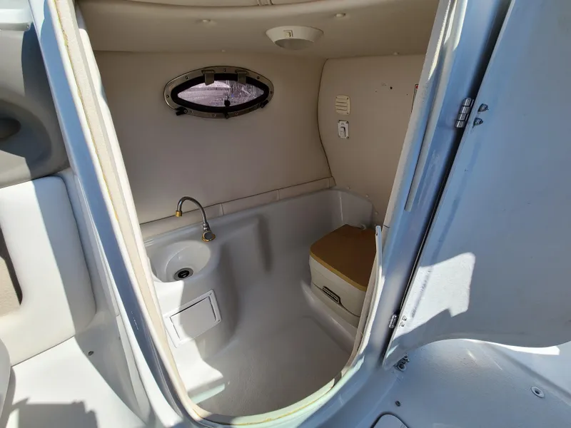 Slide: The Image of 2003 Crownline 230BR boat interior cabin with sink and porthole window. - 31