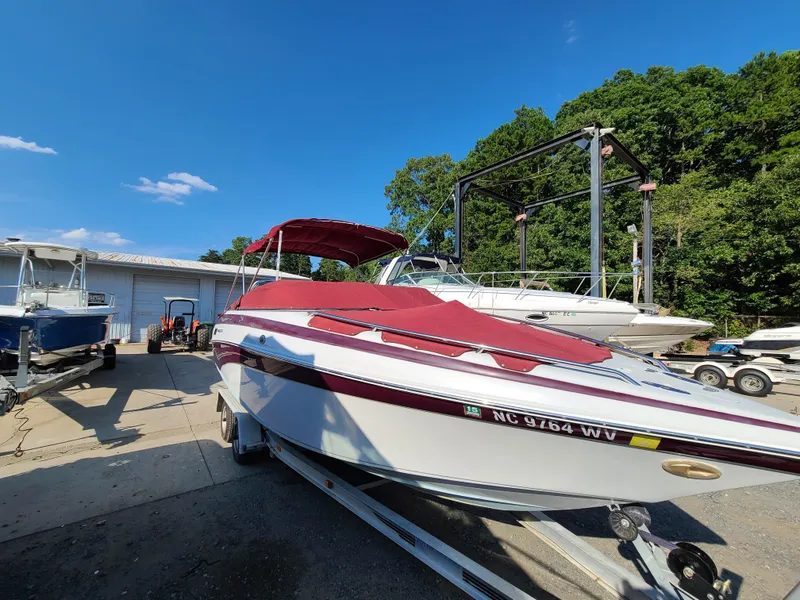Slide: The Image of 2003 Crownline 230BR boat with red cover on trailer at marina. - 4