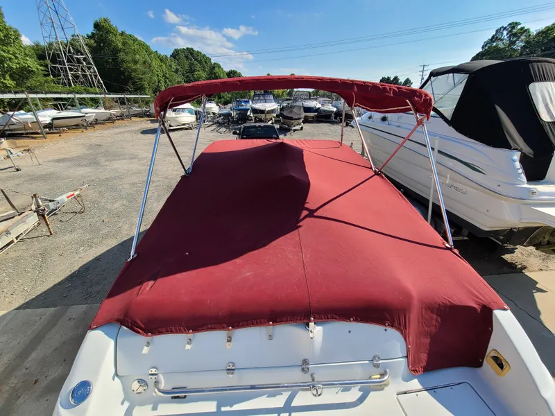 Slide: The Image of 2003 Crownline 230BR boat with red cover in a marina. - 6