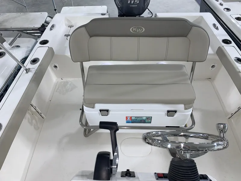 Slide: The Image of 2024 Key West 188 Bay Reef boat interior with steering wheel and cushioned seating. - 8