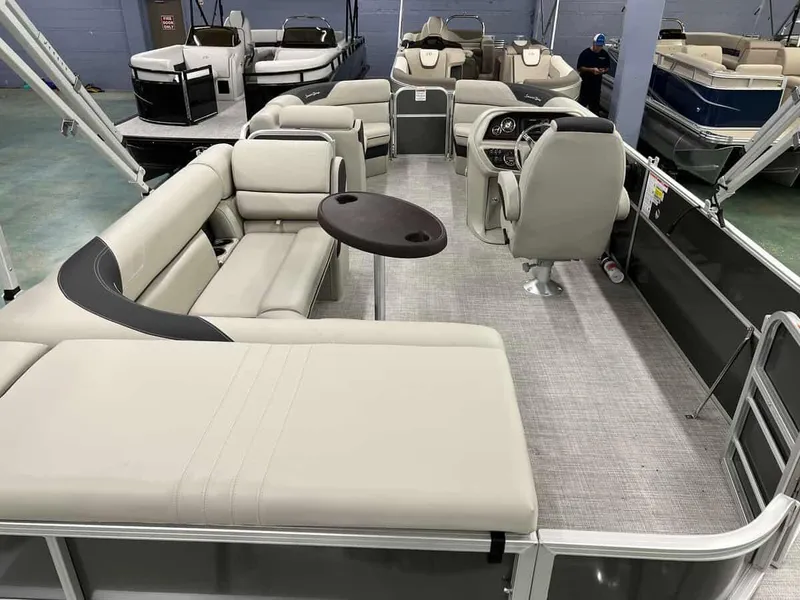 Slide: The Image of 2023 South Bay 222 CR LE 2.75 pontoon boat interior with beige seating and captain's chair. - 11