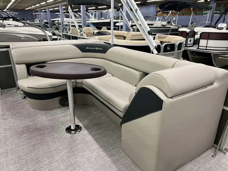 Slide: The Image of 2023 South Bay 222 CR LE 2.75 pontoon boat interior with beige seating and round table. - 5