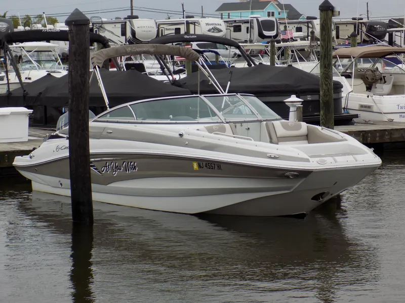 Slide: The Image of 2018 Crownline Eclipse E23 XS boat docked in marina, surrounded by other vessels. - 1
