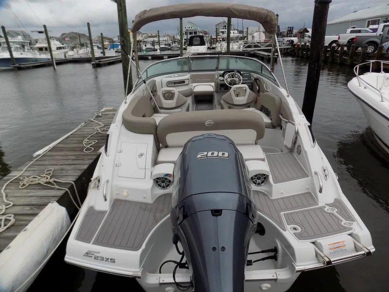 Slide: The Image of 2018 Crownline Eclipse E23 XS boat docked at marina, featuring spacious seating and powerful engine. - 4
