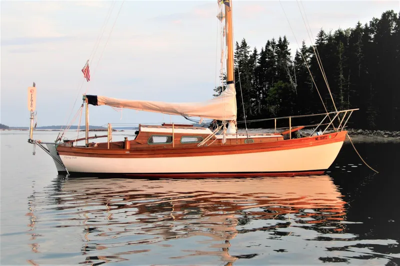 The Image of Laurent Giles Vertue Class Sloop, 2010, anchored on calm water with forested shoreline. - 0