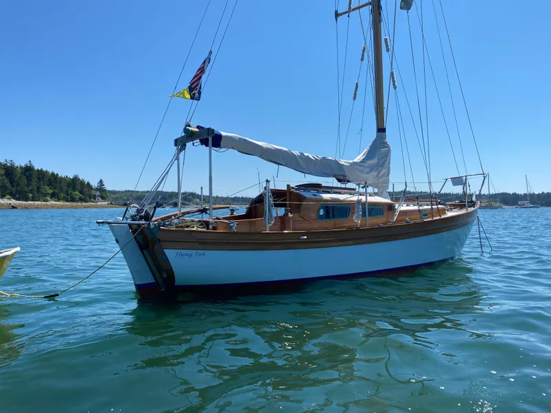 Slide: The Image of Laurent Giles Vertue Class Sloop, 2010, anchored in calm waters under clear blue sky. - 2