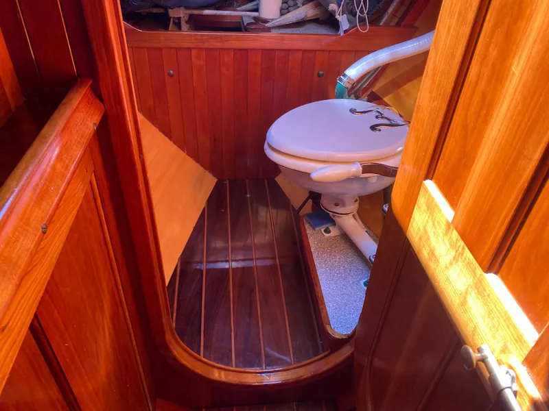 Slide: The Image of Interior of 2010 Laurent Giles Vertue Class Sloop, featuring wooden paneling and marine toilet. - 22
