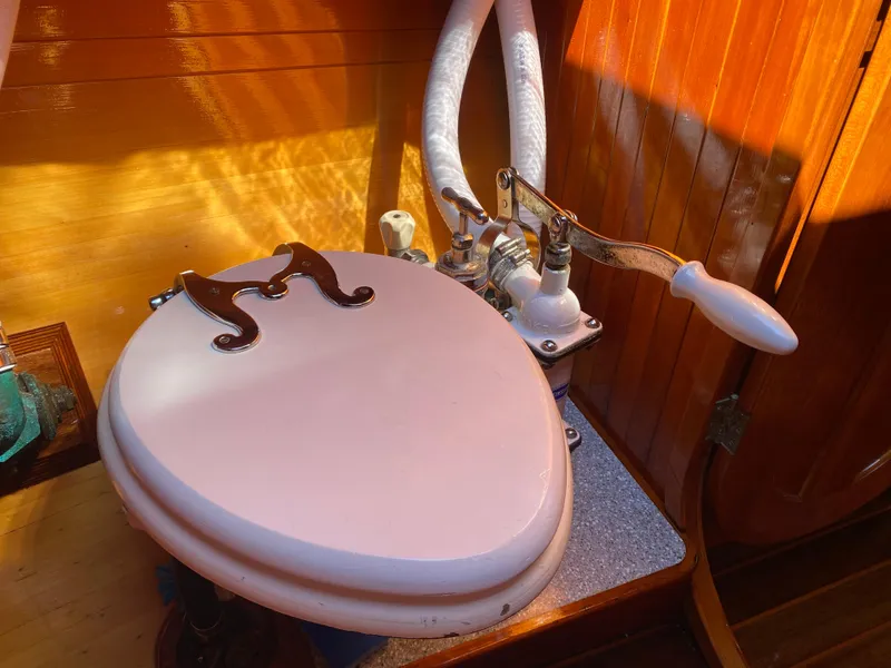 Slide: The Image of 2010 Laurent Giles Vertue Class Sloop marine toilet with wooden accents and manual pump handle. - 25