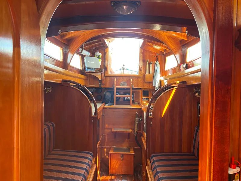 Slide: The Image of Interior of 2010 Laurent Giles Vertue Class Sloop, featuring rich wood paneling and striped seating. - 30