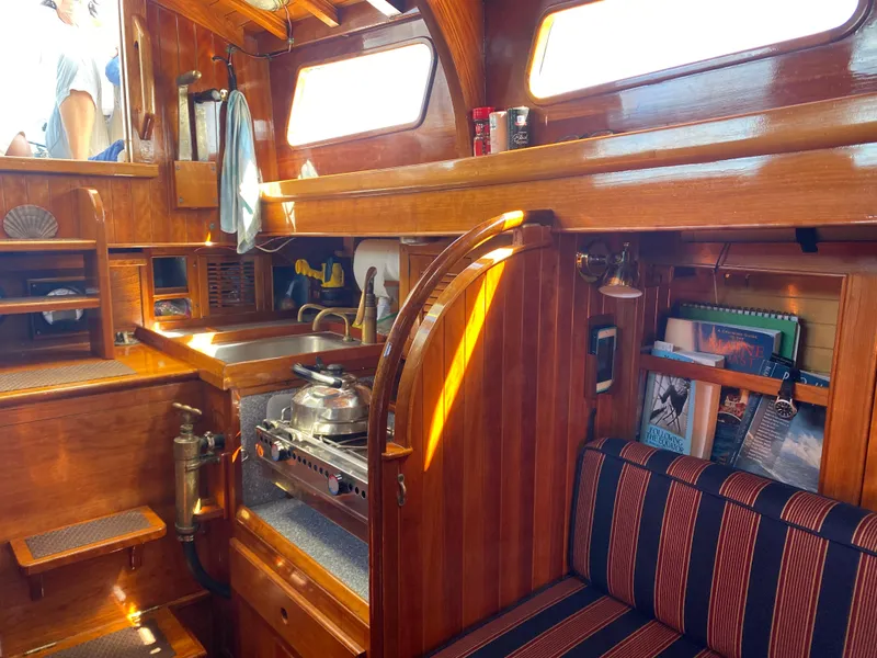 Slide: The Image of Interior of 2010 Laurent Giles Vertue Class Sloop, featuring wooden cabinetry and compact kitchen area. - 39