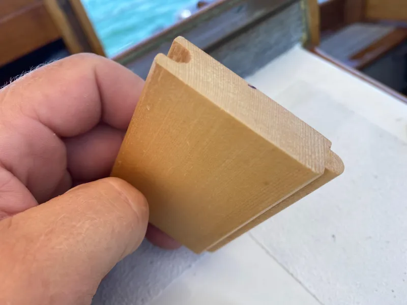 Slide: The Image of Hand holding a wooden piece on Laurent Giles Vertue Class Sloop, 2010 model. - 47