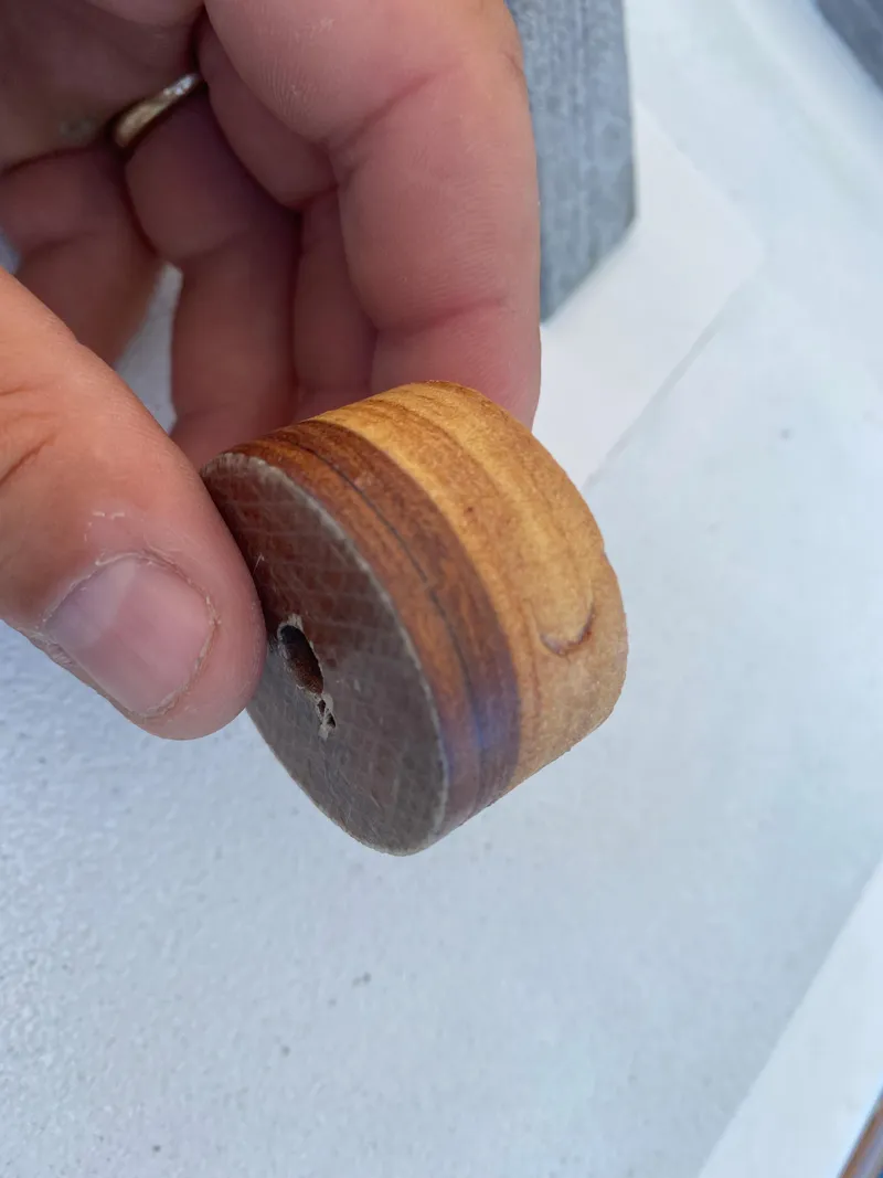 Slide: The Image of Hand holding a small, round wooden piece from a 2010 Laurent Giles Vertue Class Sloop. - 48