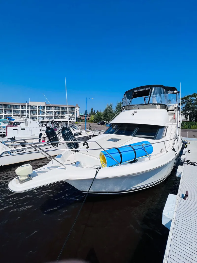 Slide: The Image of 1999 Silverton 392 Motor Yacht docked at marina under clear blue sky. - 7