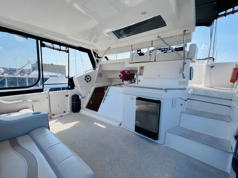 Slide: The Image of 1999 Silverton 392 Motor Yacht interior with seating, kitchenette, and steps, featuring modern amenities. - 8