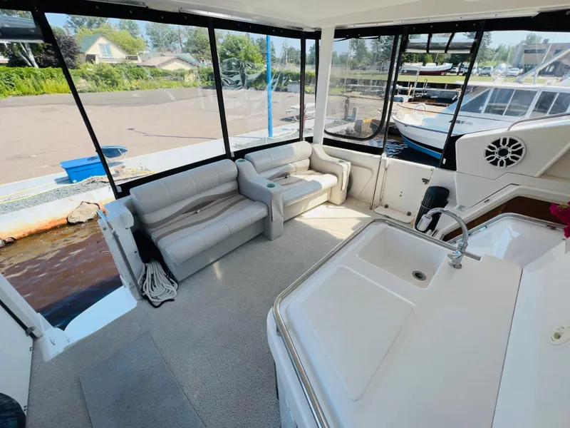 Slide: The Image of 1999 Silverton 392 Motor Yacht interior with seating and kitchenette, docked at marina. - 9
