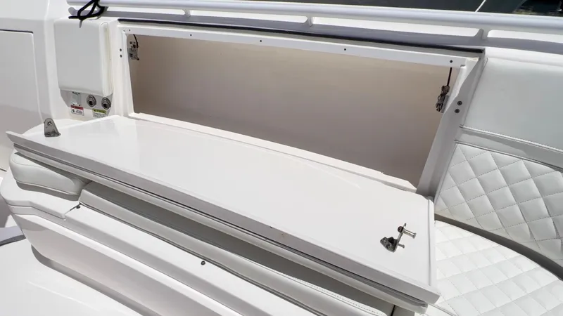 Slide: The Image of Open storage compartment on a 2020 Intrepid 345 Nomad boat with quilted seating. - 11