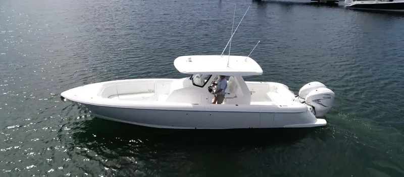 Slide: The Image of 2020 Intrepid 345 Nomad boat on calm water, side view. - 14