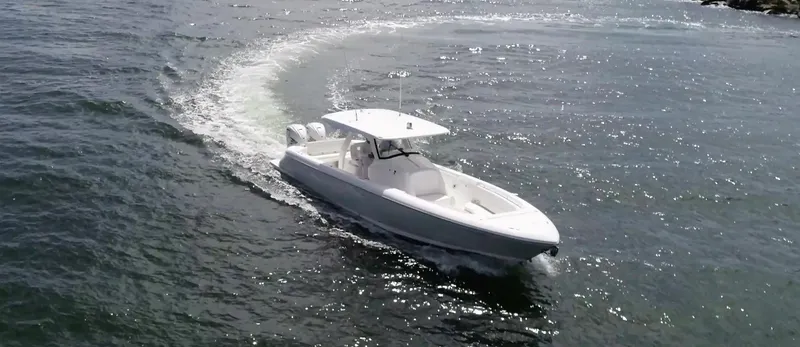 Slide: The Image of 2020 Intrepid 345 Nomad boat cruising on open water, creating a gentle wake. - 15