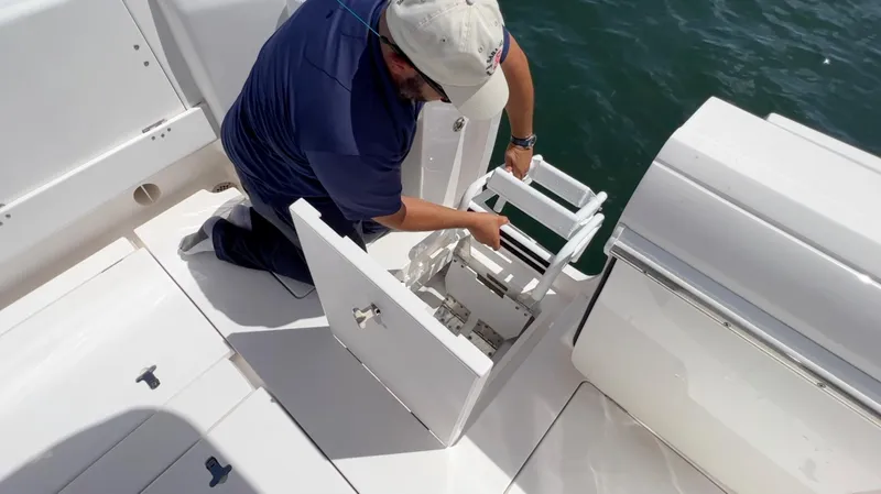 Slide: The Image of Man adjusting ladder on 2020 Intrepid 345 Nomad boat deck. - 3