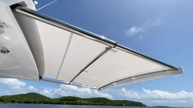 Slide: The Image of 2020 Intrepid 345 Nomad boat canopy against clear blue sky and scenic island backdrop. - 6