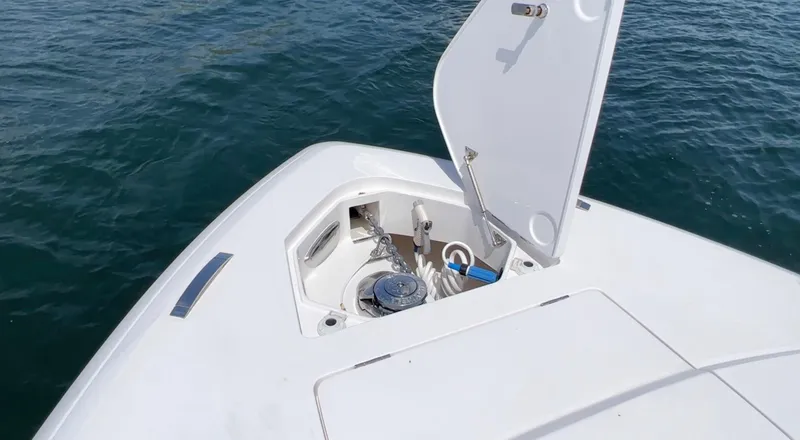 Slide: The Image of 2020 Intrepid 345 Nomad boat anchor compartment open on calm water. - 7